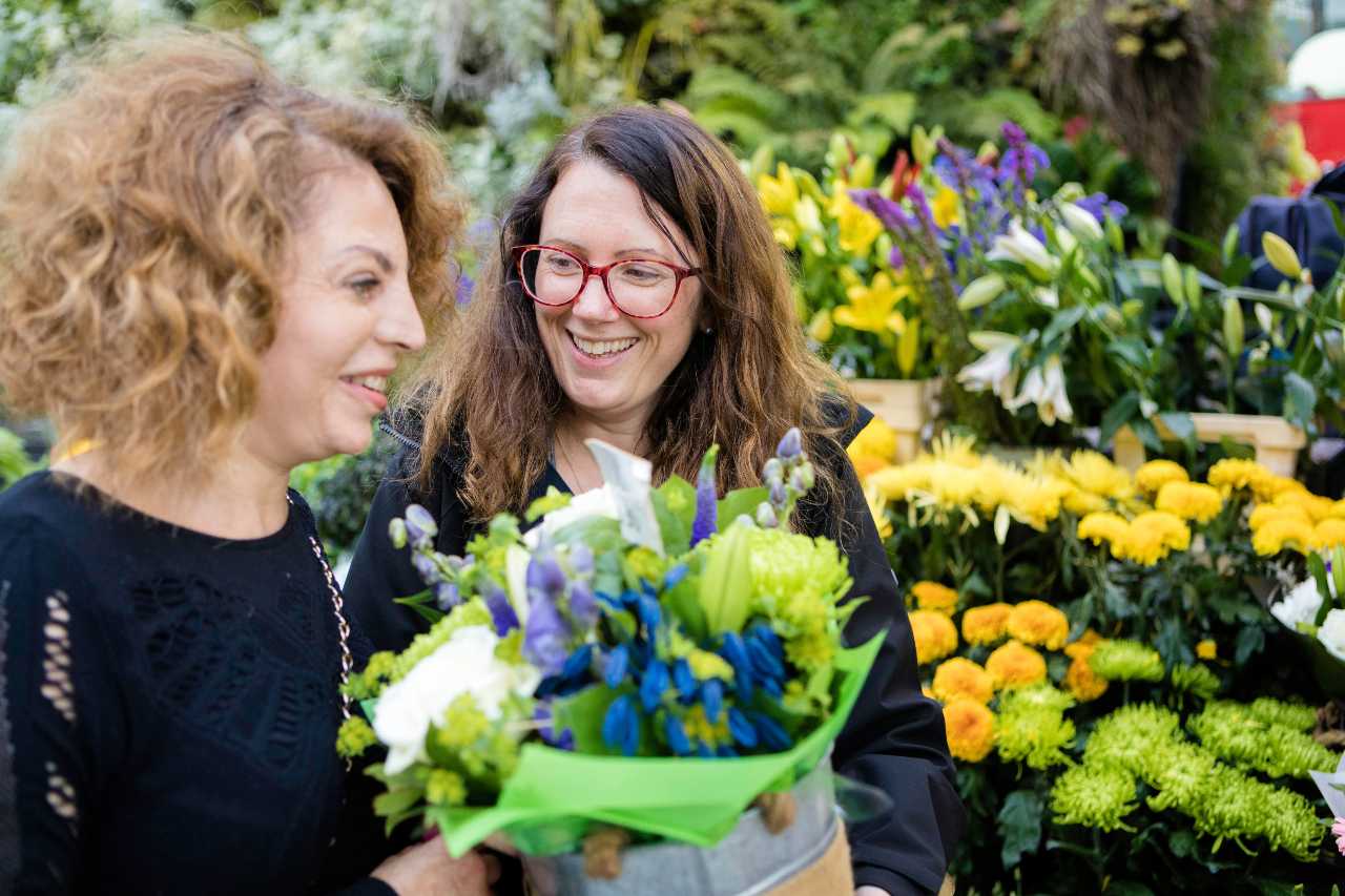 My Guide volunteer presenting flowers to a service user at a flower shop