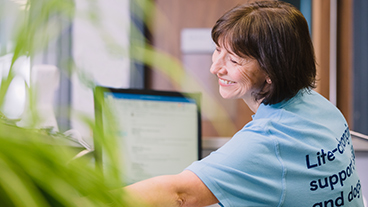 Woman smiling in front of her computer-screen