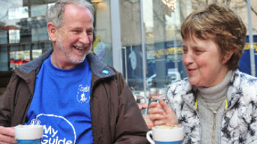 My guide volunteer and a service user drinking a hot drink