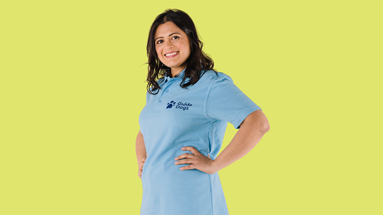 Guide Dogs volunteer smiling against yellow background