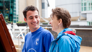A guide dog volunteer assists a person with partial sight