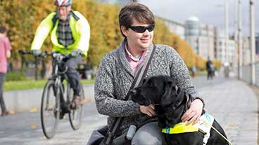 Guide dog owner crouching down next to his guide dog