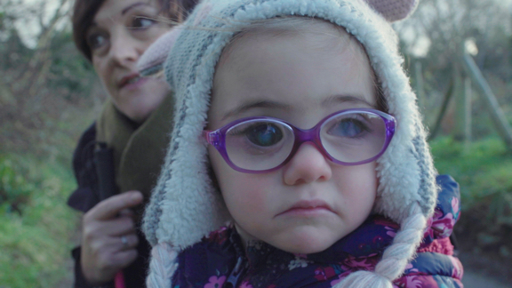 Nell wearing glasses and a hat outside
