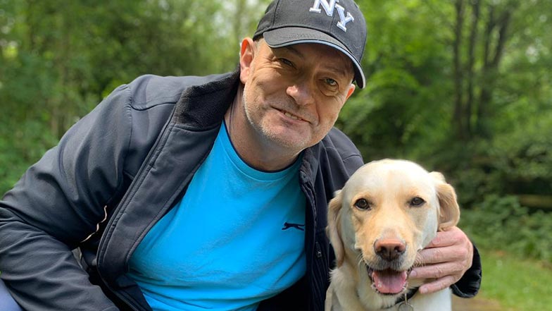 uide-dog-owner Michael-and-his-golden-labrador-guide-dog-looking-at-the-camera