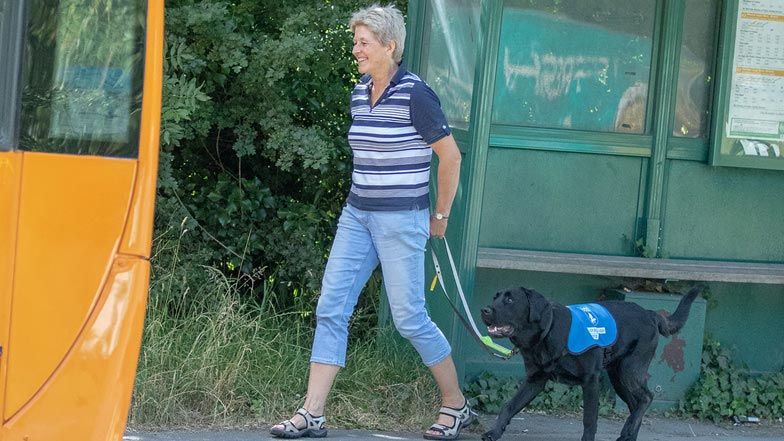 Alfie and his Puppy Walker Isobel walking on the pavement towards a bus Alfie and his Puppy Walker Isobel walking on the pavement towards a bus