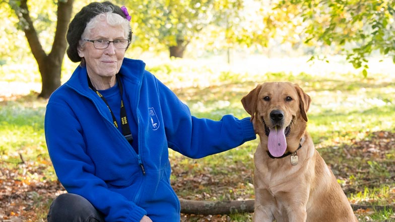 Oscar sitting next to Guide Dog trainer Glyn Oscar sitting next to Guide Dog trainer Glyn
