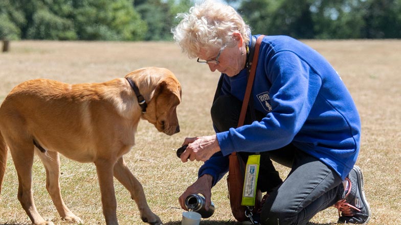 Glyn Oscars Puppy Walker giving him a drink of water Glyn Oscars Puppy Walker giving him a drink of water