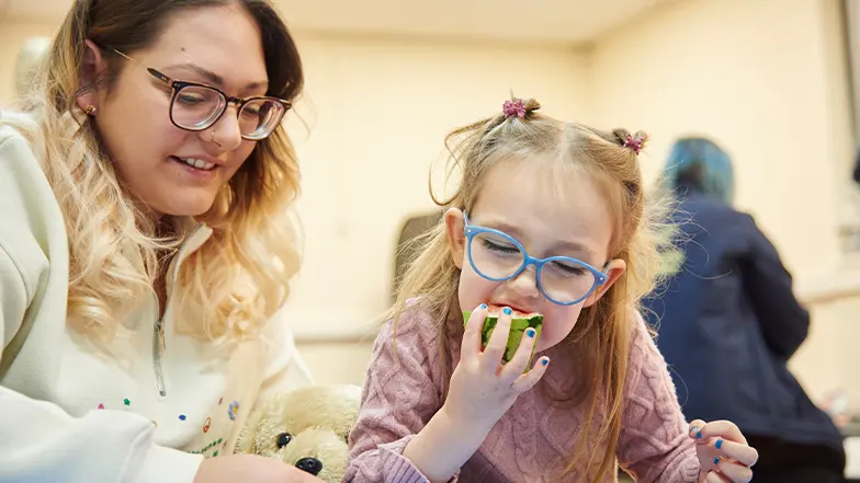 Ruby eating watermelon with her mum during a My Time to Play session