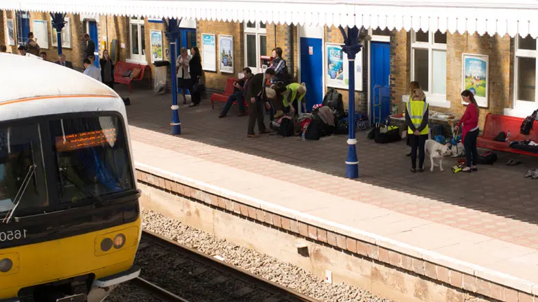 Image of passengers waiting on a train station platform.