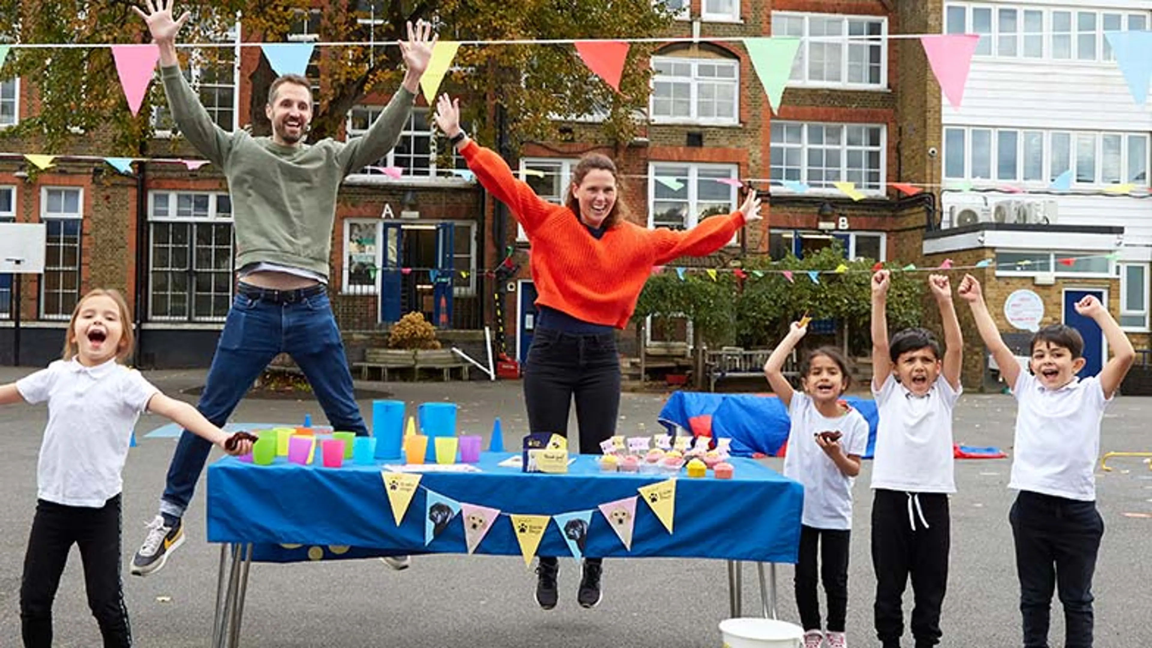Stall set up at a school with teachers and children to raise money for Guide Dogs.