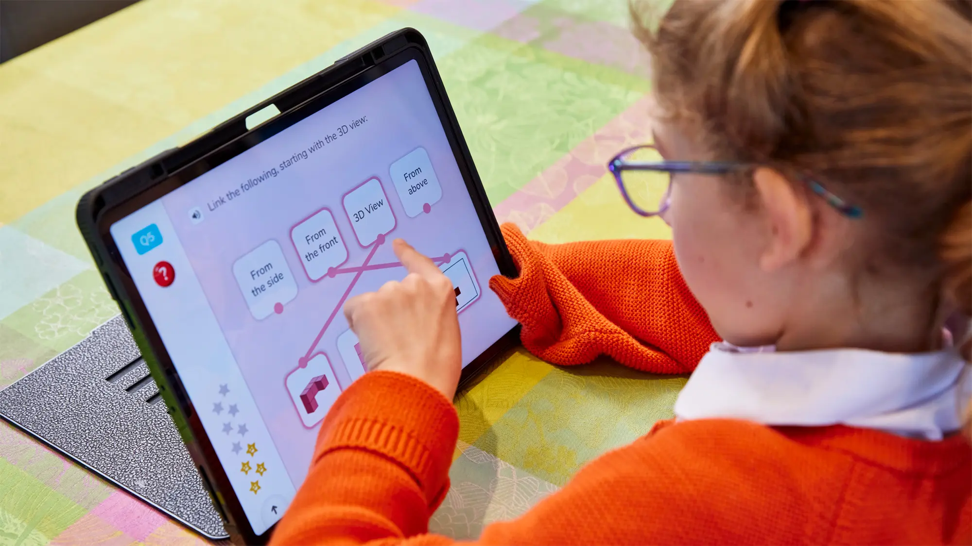 Josie, a child who has a vision impairment, is pictured carrying out a phrase and picture matching task on her iPad.