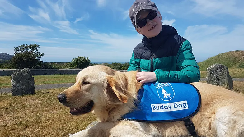 Ellis smiling with buddy dog, Ralph, outside