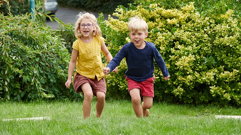 Josie plays with her brother in the garden.