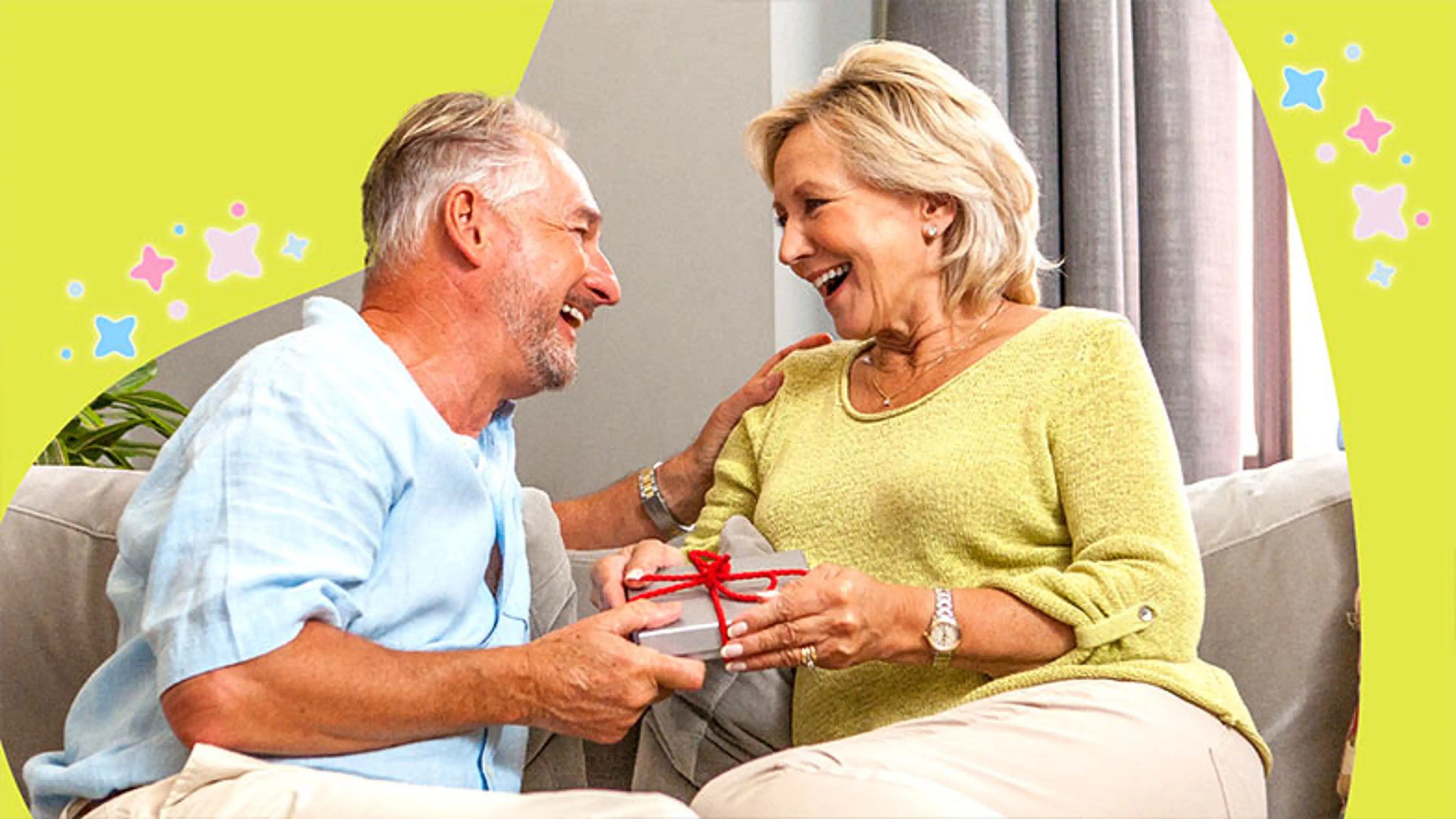 A man and woman sit together holding a present