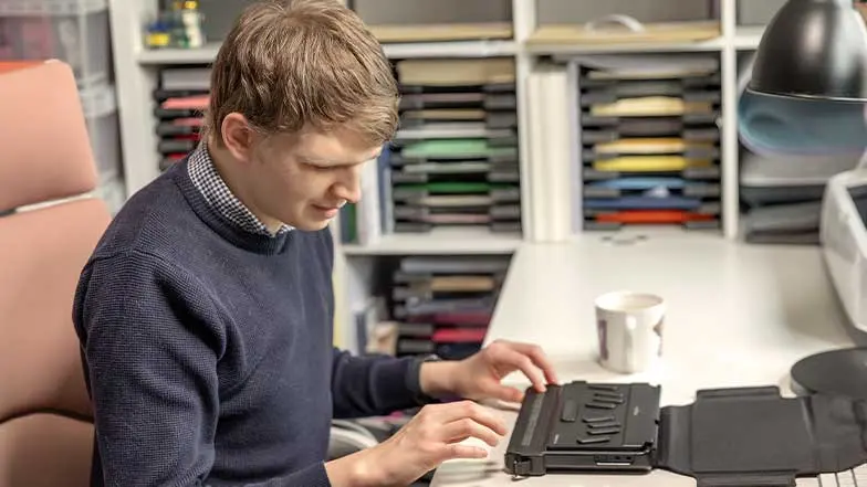 Callum using his Humanware Brailliant Braille display machine.