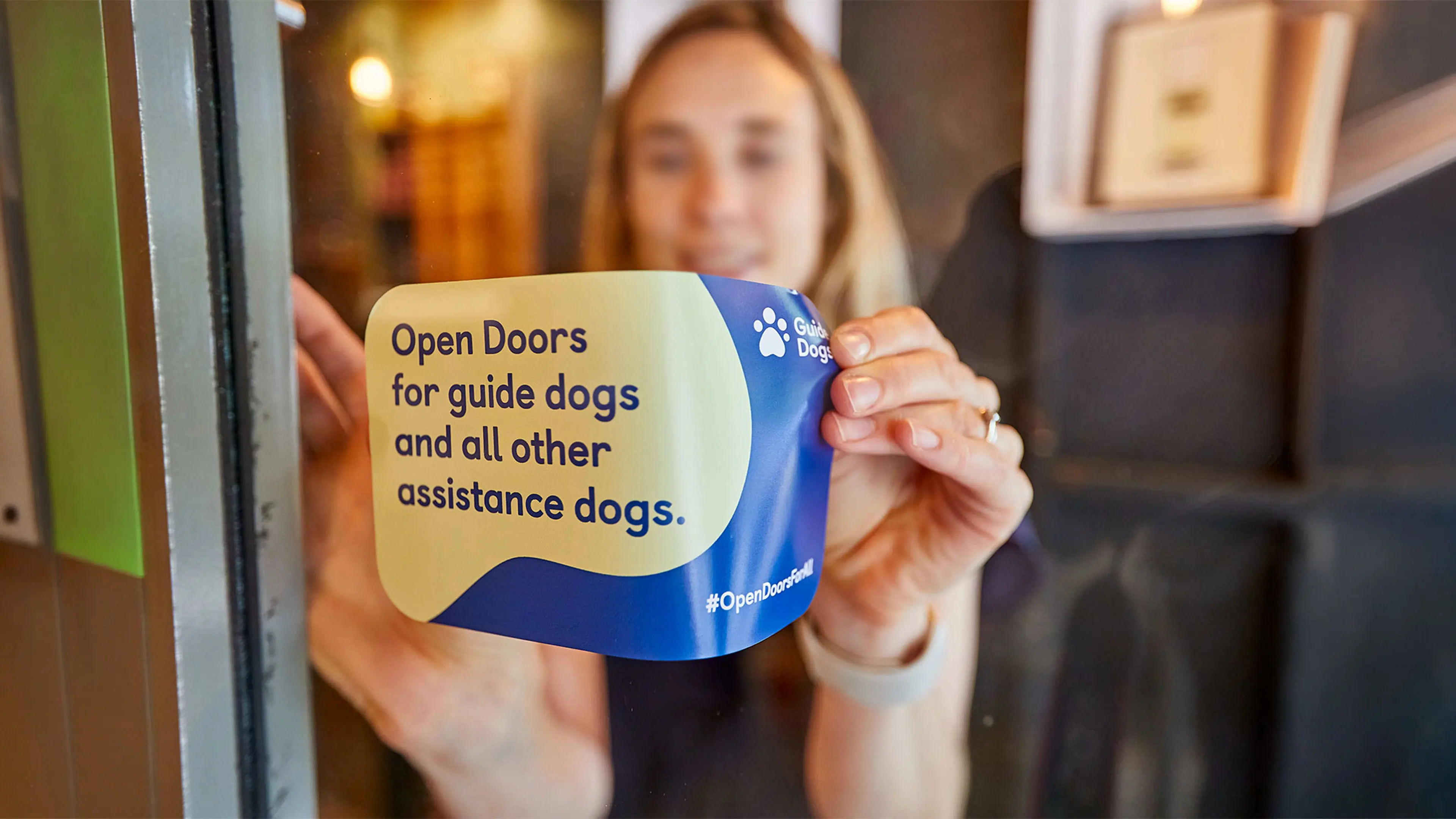 A Guide Dogs campaigner adds an 'Open Doors for guide dogs and all assistance dogs' 