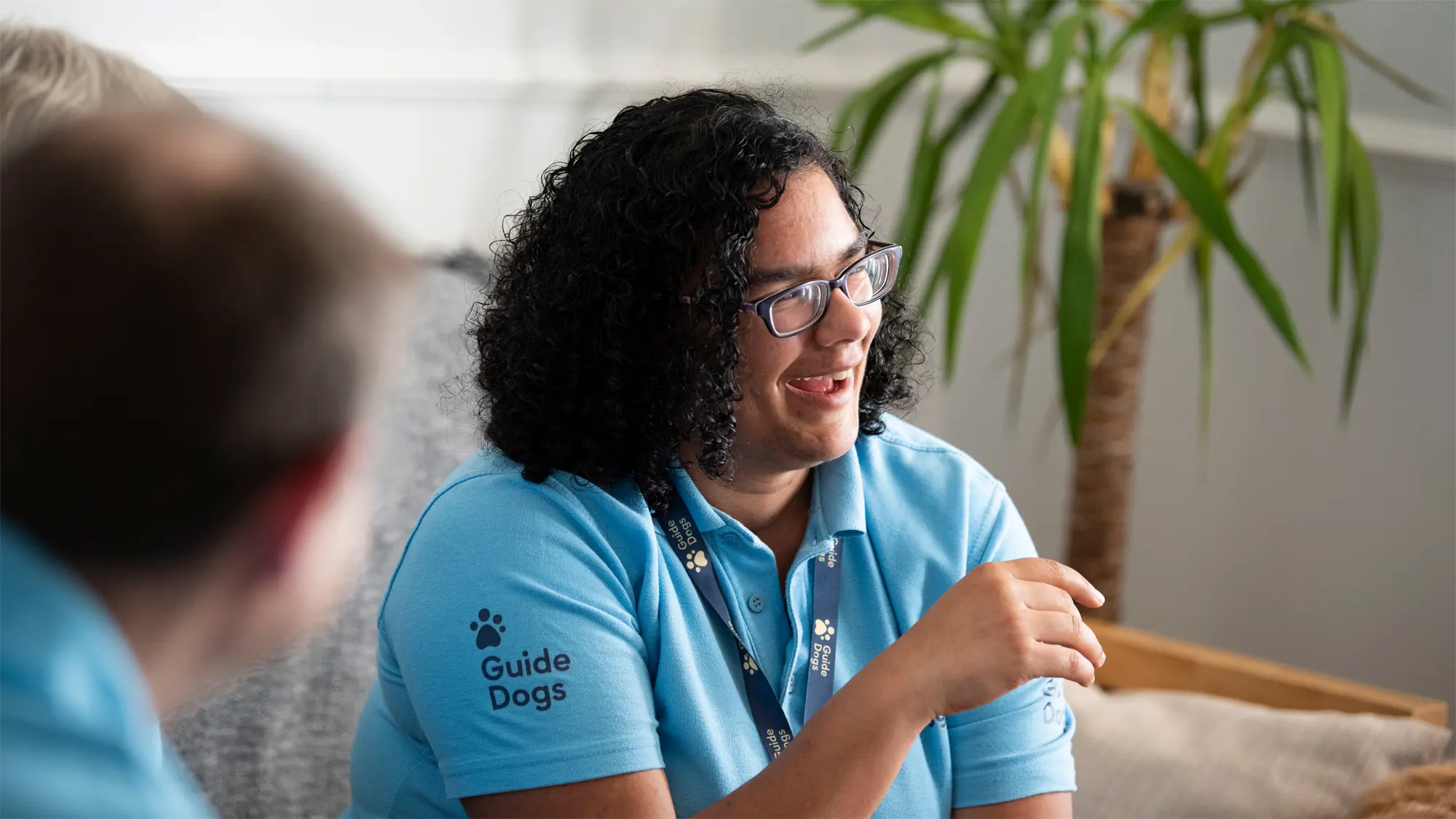 Lena, a guide dog owner and Fundraising Group Co-Ordinator, laughs and smiles with other volunteers.
