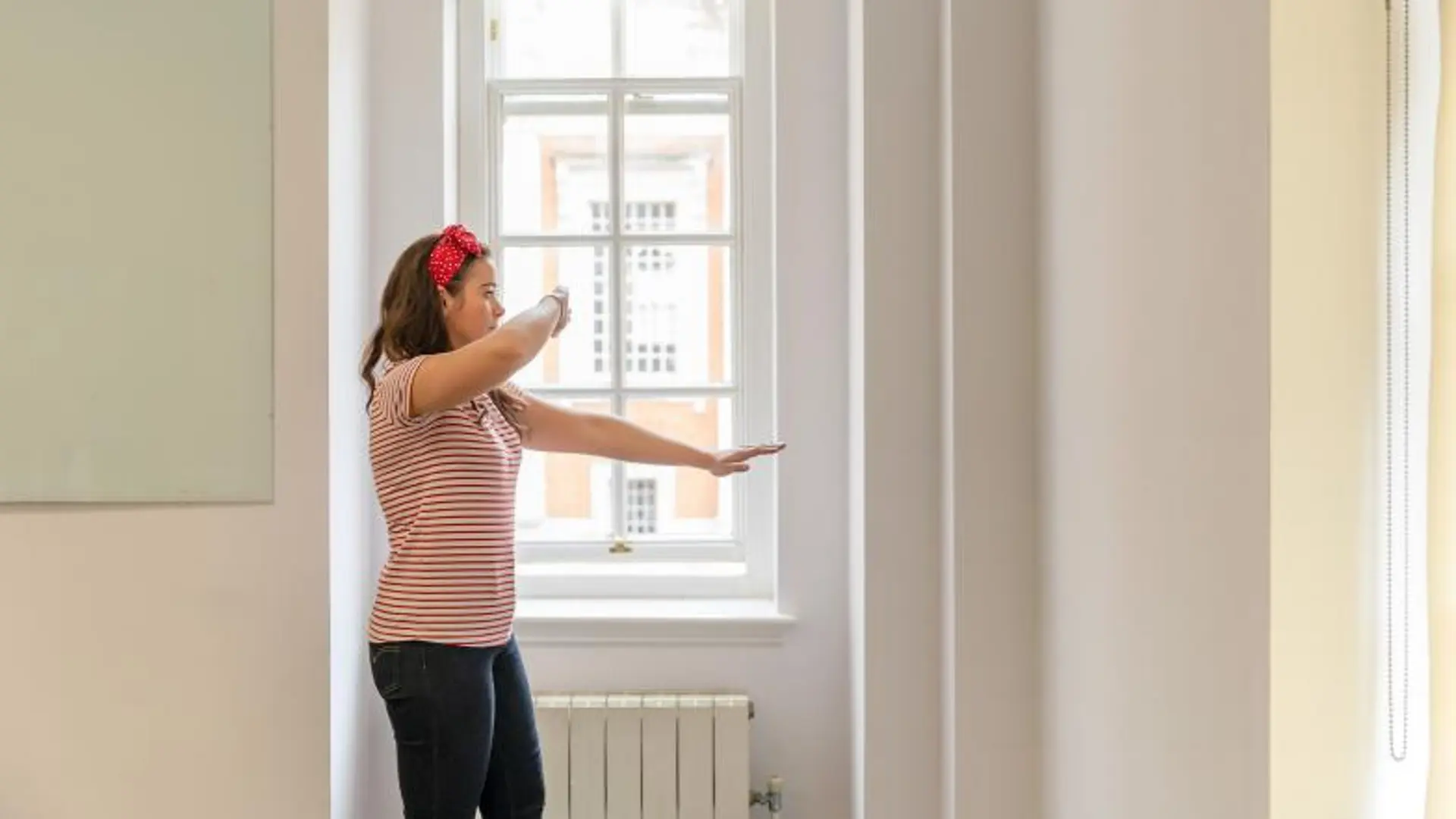 A woman walks past a window using the technique described above, with one arm outstretched and the other protecting her face