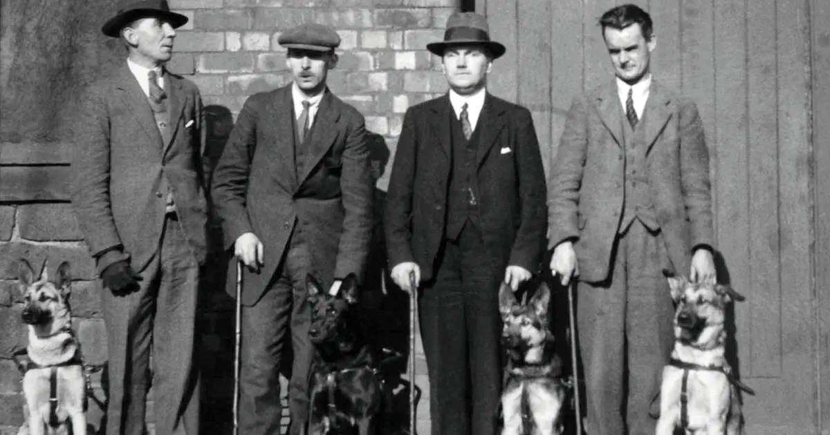 Black and white photograph showing some of the first Guide Dog owners and their dogs