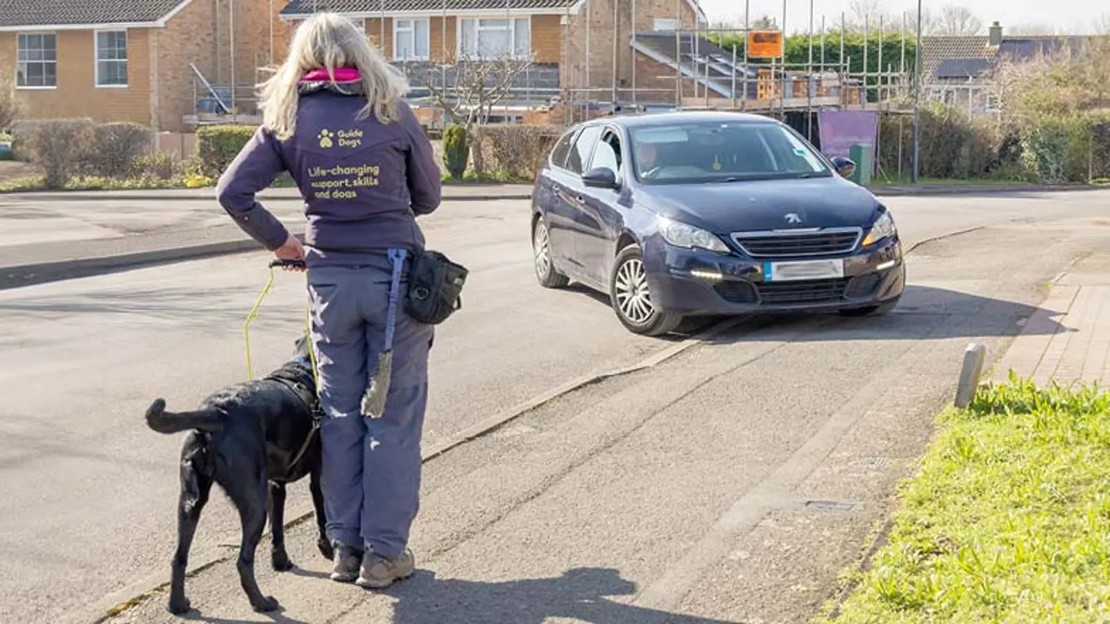 GDMS Nicola and Sage standing on a footpath waiting for a car as it turns into a driveway.
