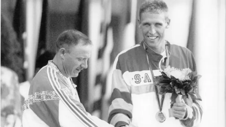 A black and white photo of Tim accepting a medal.