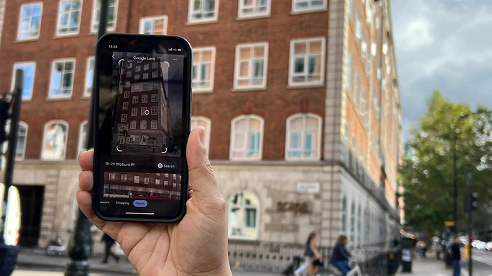 A person uses Google Lens to identify the building in front of them and its address