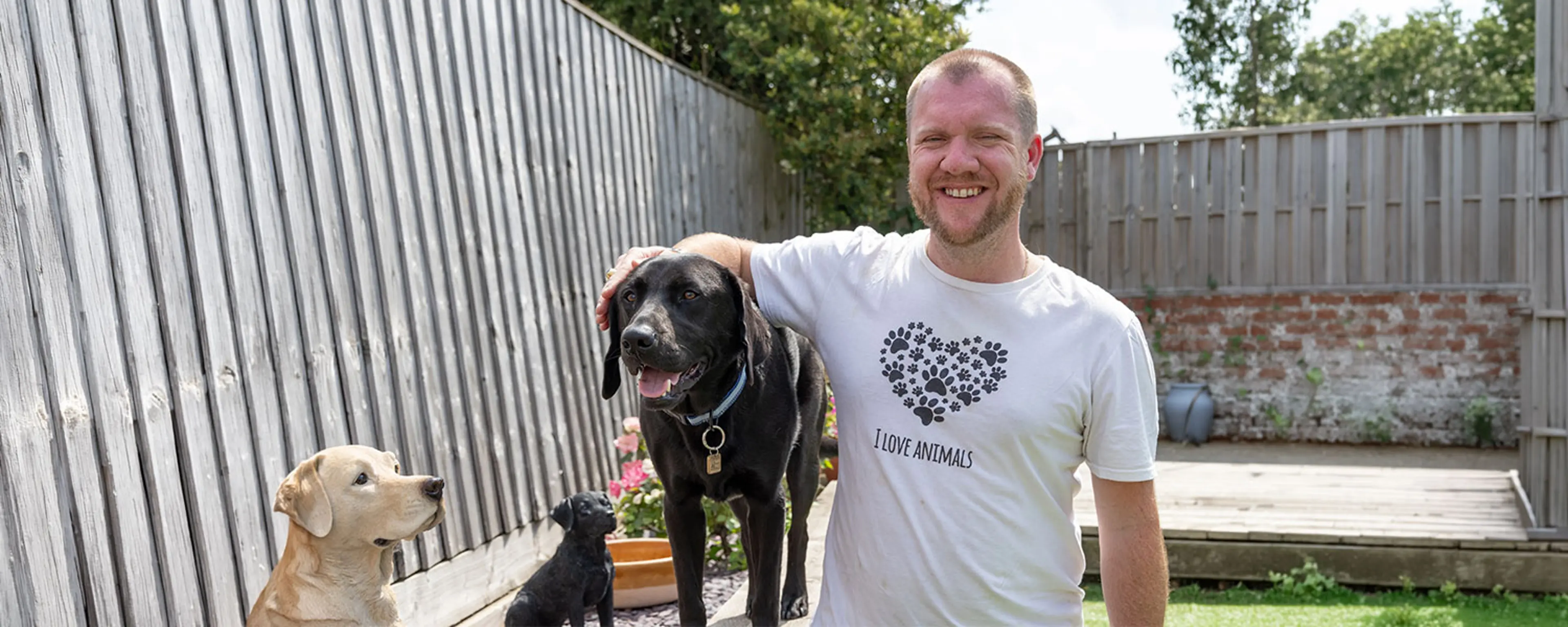 James and Comet sitting together outside. James is smiling and has his hand gently placed on Comet's ear.