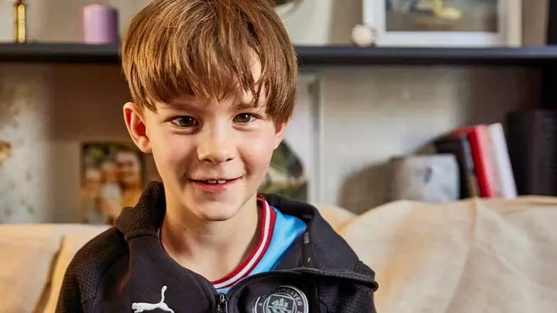 Ralph, a young service user, smiles to camera.