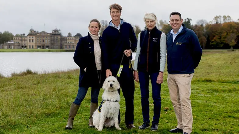Image shows (from left to right): Alice Plunkett, Racing journalist, William Fox-Pitt, Olympic Event Rider, Jane Tuckwell, MARS Badminton Horse Trials organiser, and Andrew Lennox, Guide Dogs CEO, in front of Badminton House, with a guide dog in training.