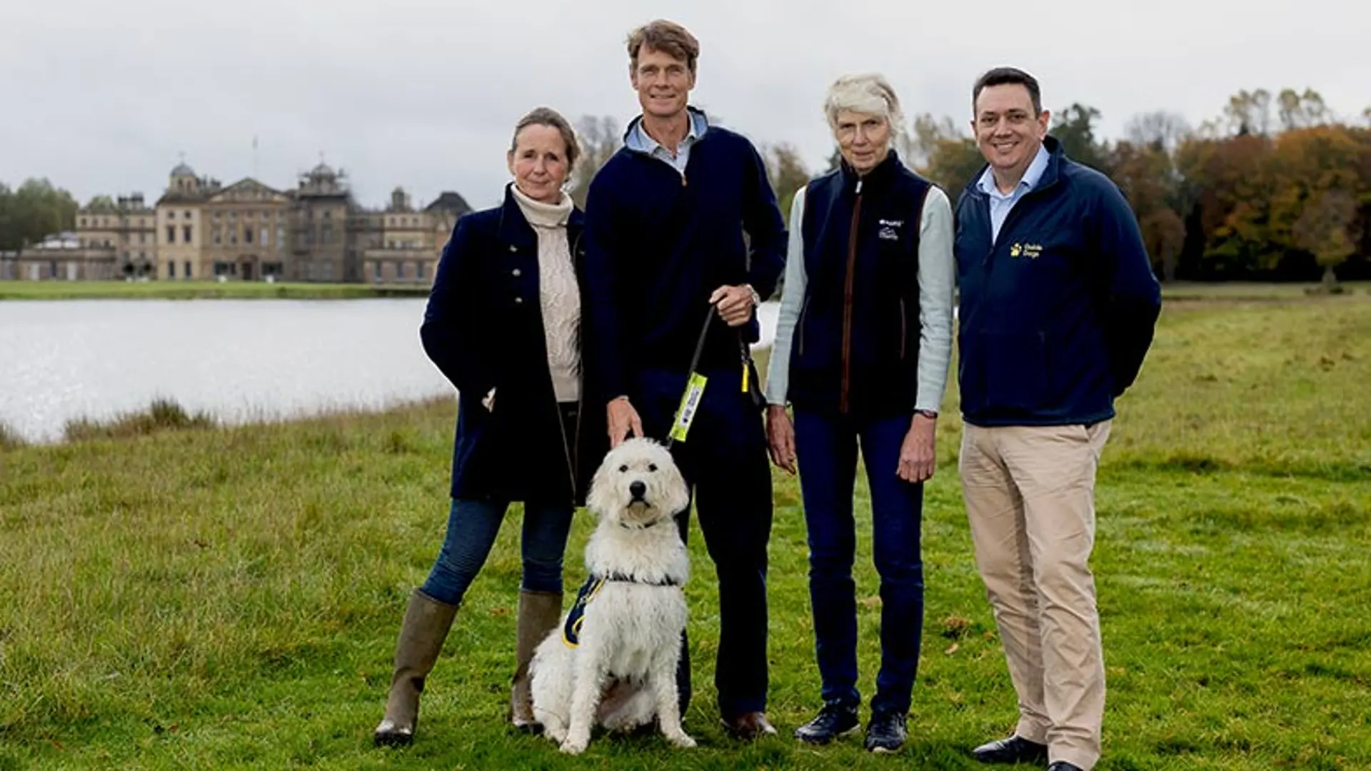 Image shows (from left to right): Alice Plunkett, Racing journalist, William Fox-Pitt, Olympic Event Rider, Jane Tuckwell, MARS Badminton Horse Trials organiser, and Andrew Lennox, Guide Dogs CEO, in front of Badminton House, with a guide dog in training.