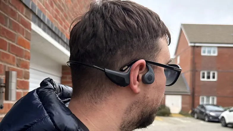 A close up of a man using the bone conducting headphones