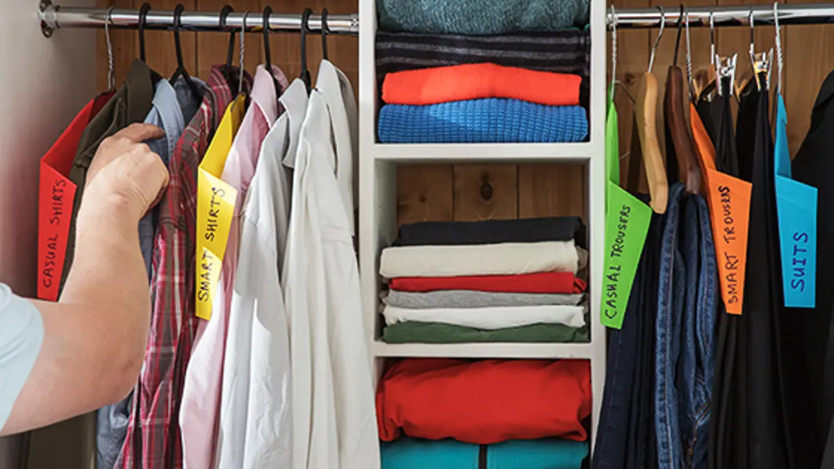 A person organising their wardrobe in a systematic way