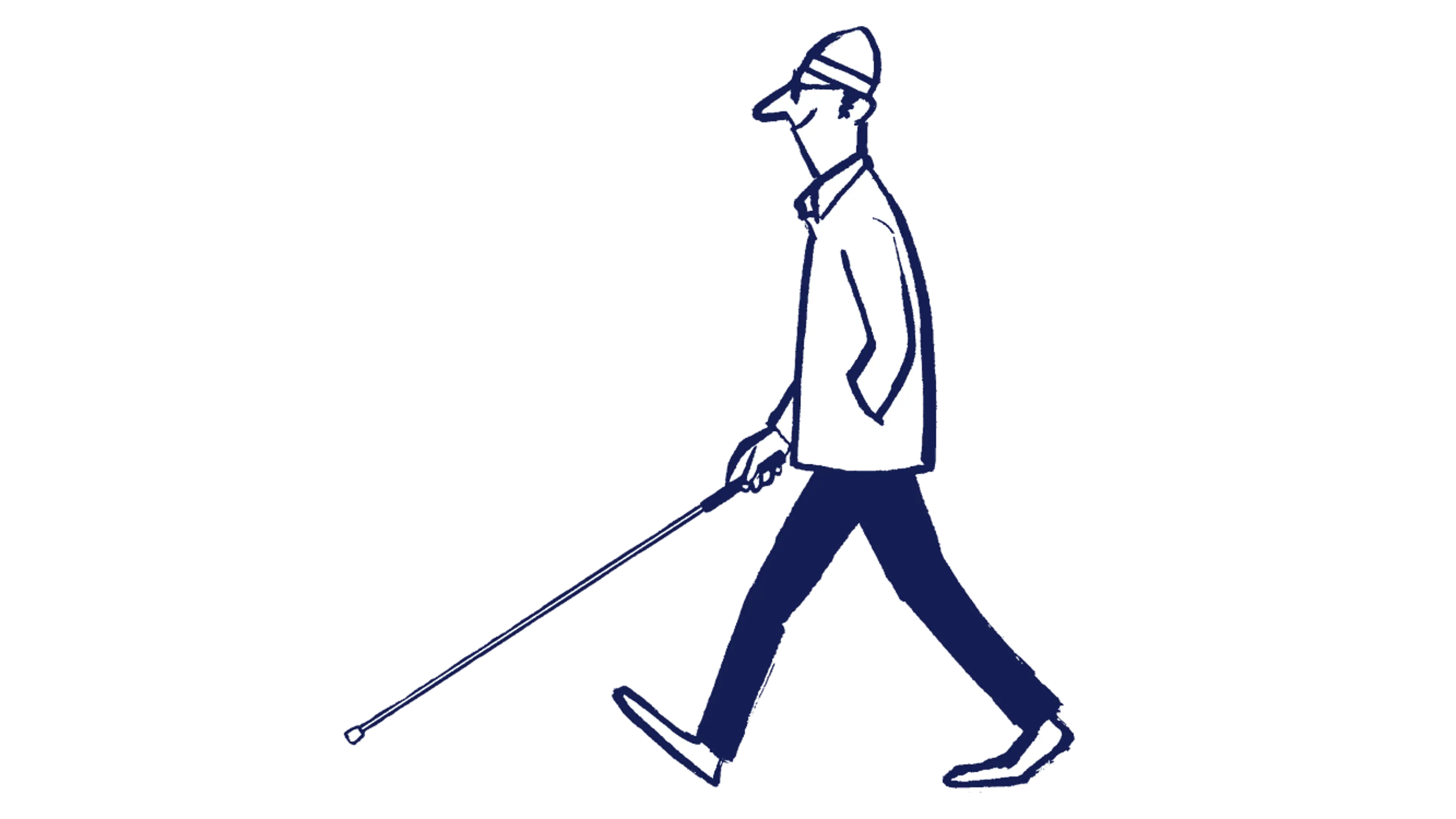 A man wearing a hat is walking using his long cane. He is smiling.