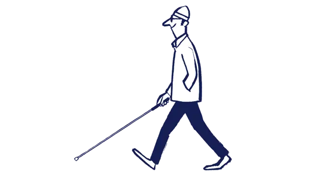 A man wearing a hat is walking using his long cane. He is smiling.