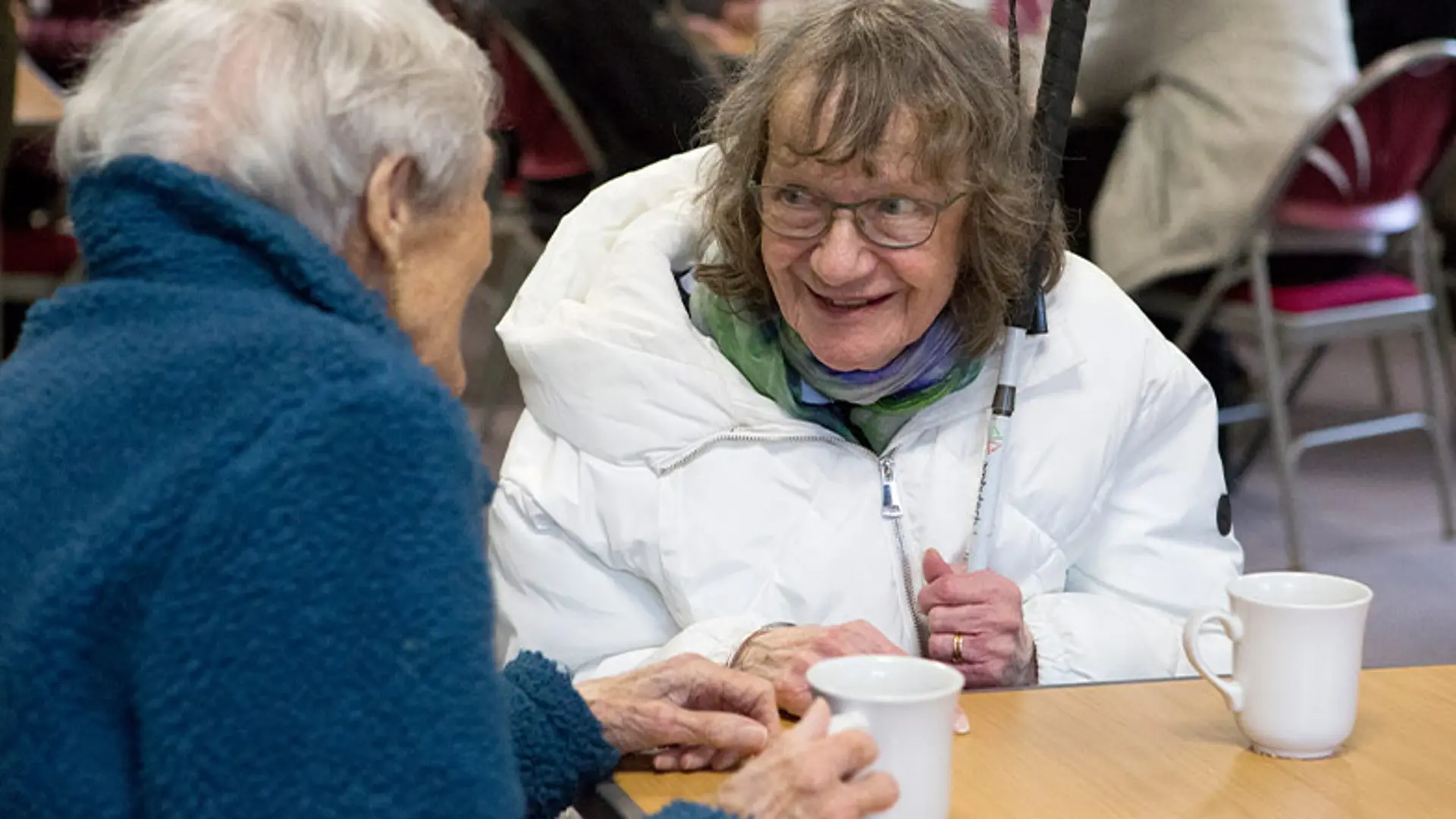 Hilary smiles as she chats to a friend over a cup of tea.
