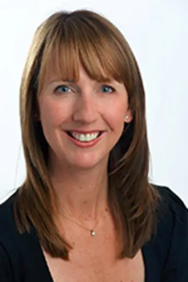 Jenelle smiles at the camera. She has long brown hair and is wearing a black top.