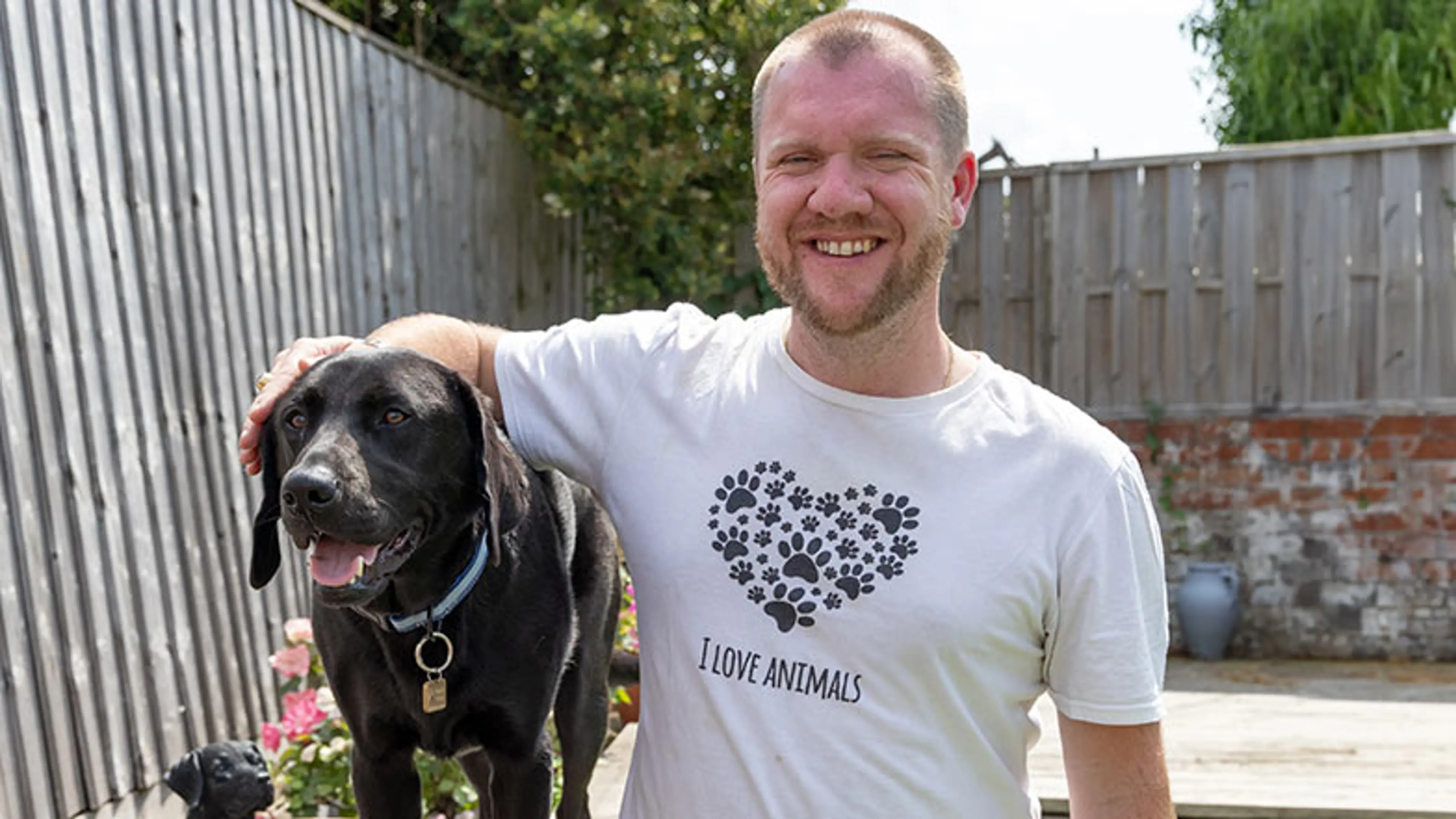 A smiling James with his arm around Comet sitting outside