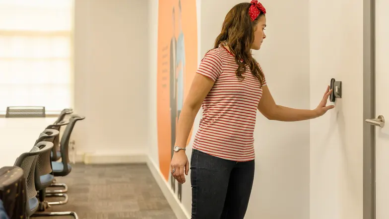 A woman reaches out her hand to familiarise herself with the perimeter of the room.