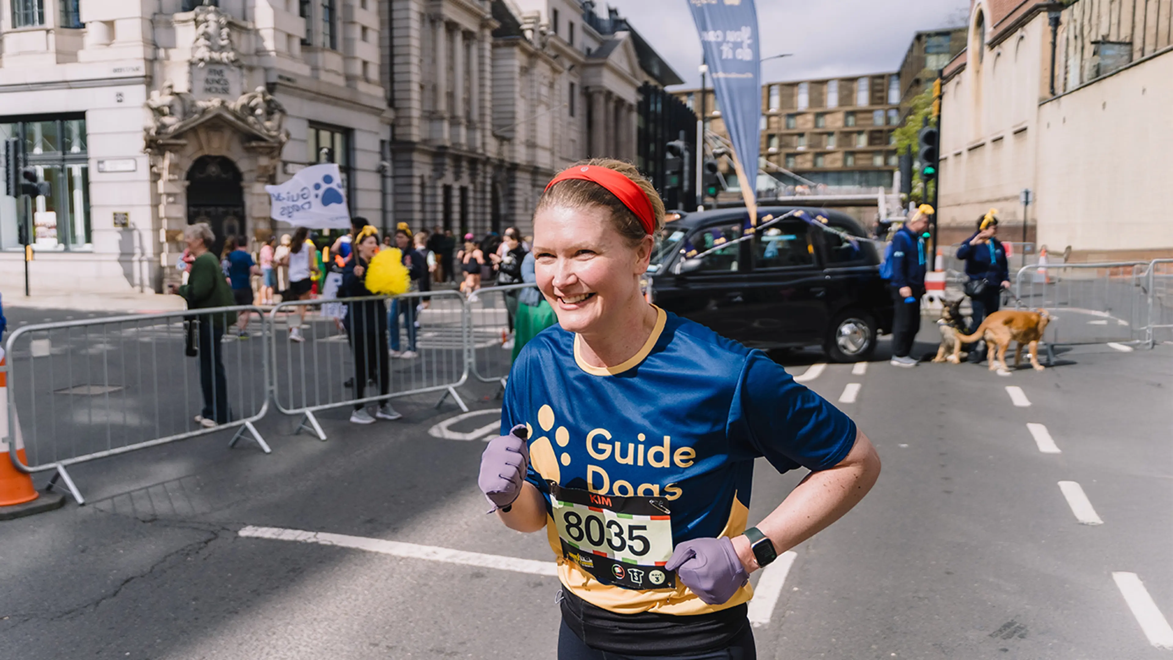 London Landmarks Half Marathon runner Kim smiles as she runs in a Guide Dogs tshirt