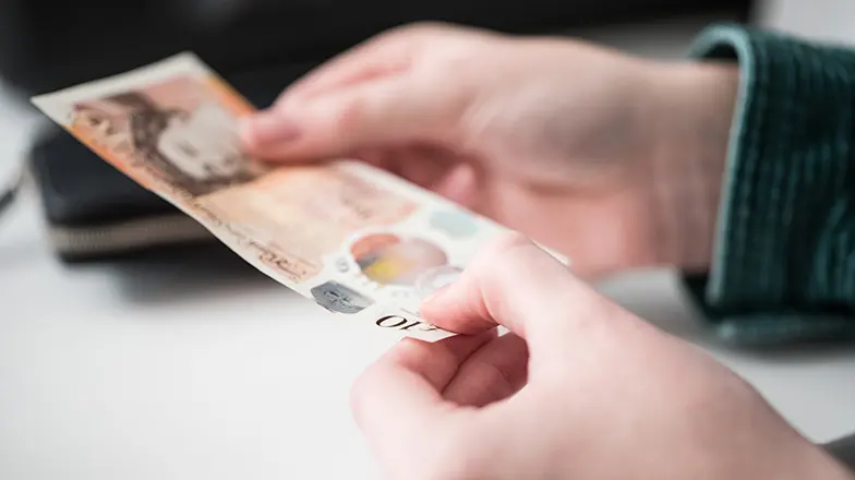 Person holding 10 pound note