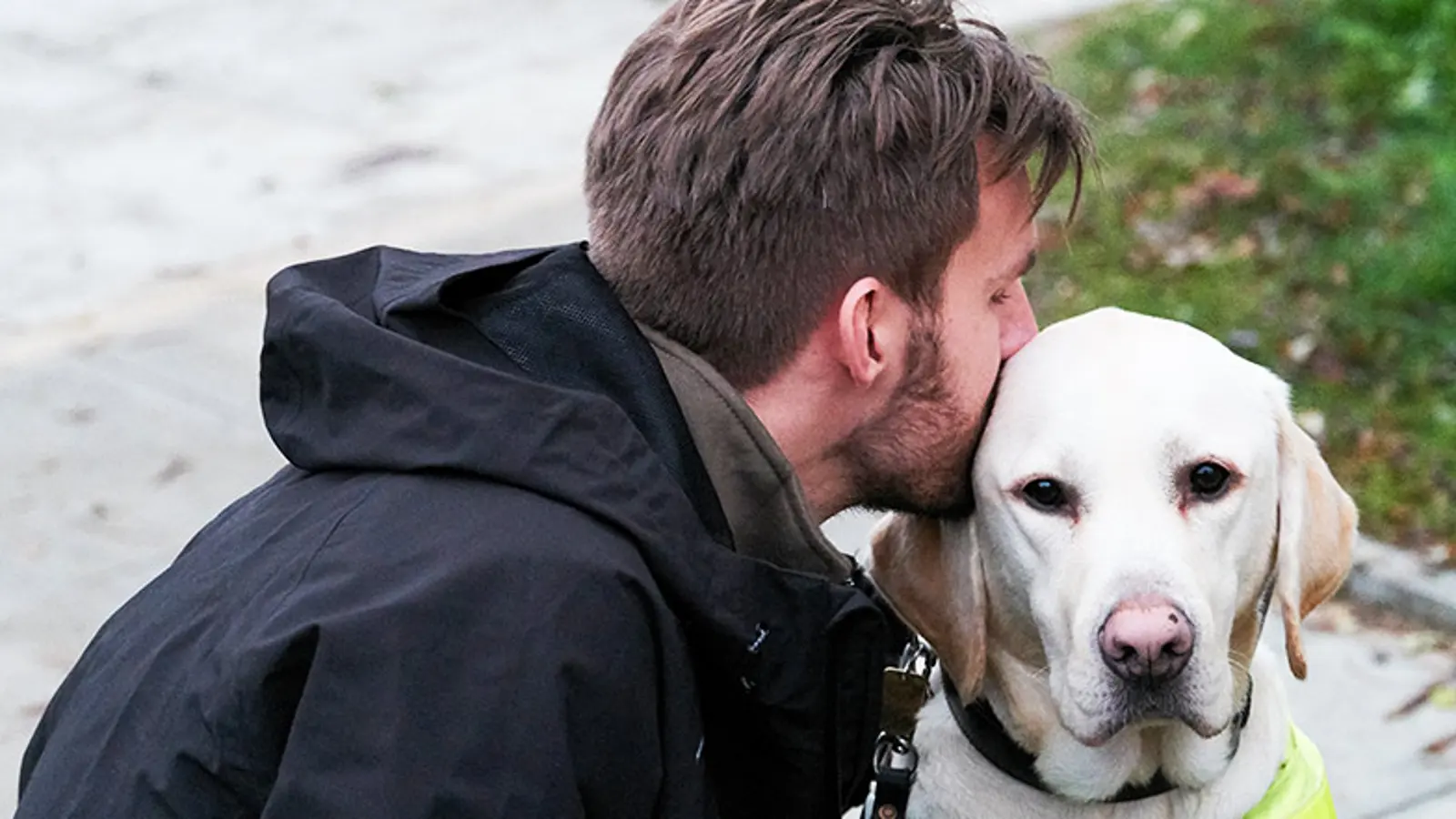 Alex kisses his guide dog River