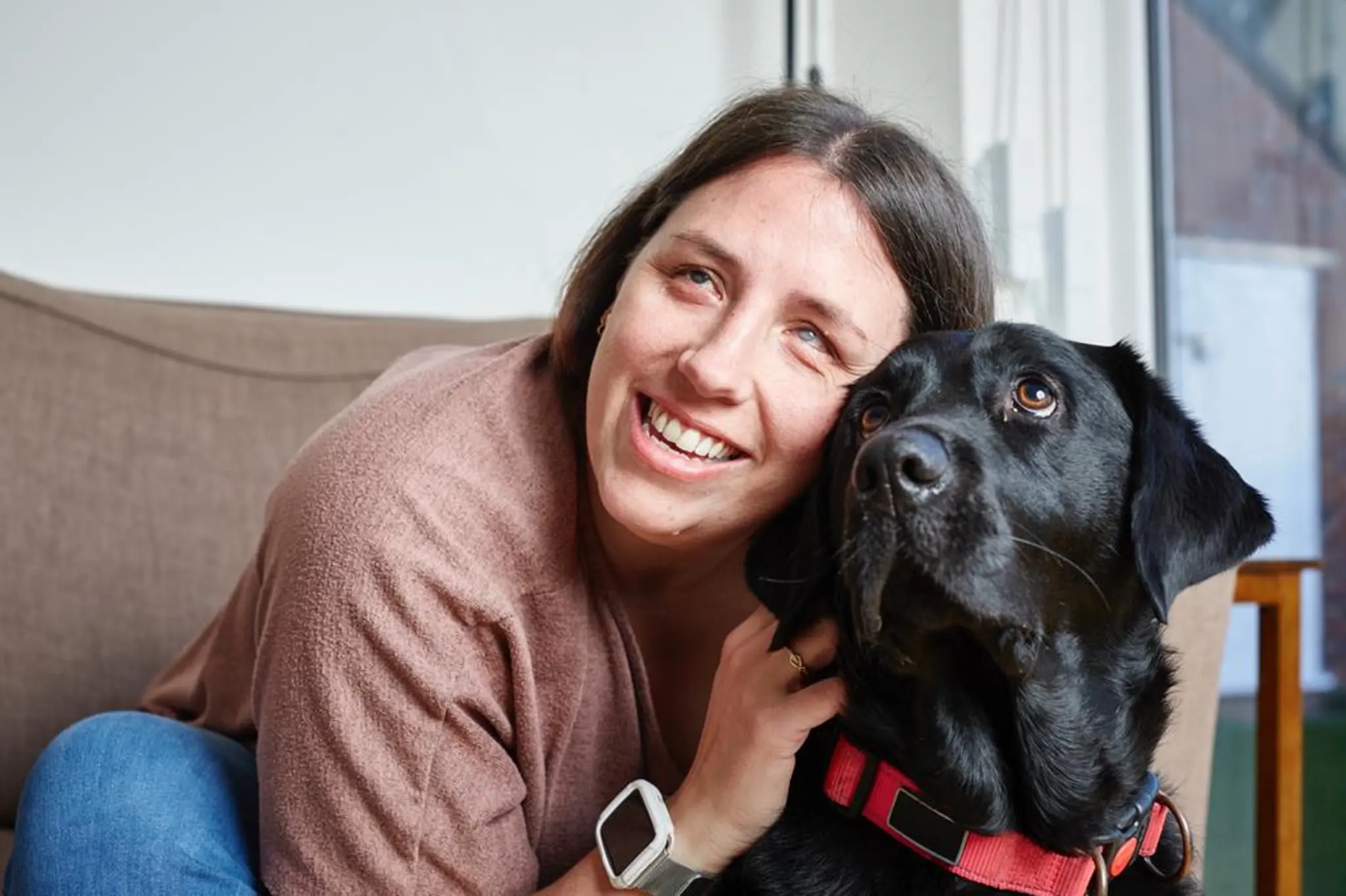 Guide dog owner Lauren smiles with her head beside guide dog Grace