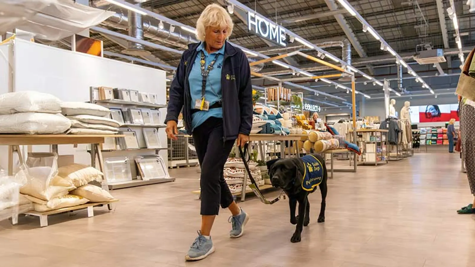 Jack and Puppy Raiser Andi walk through a shop together.