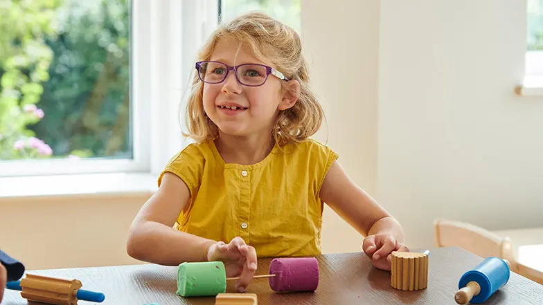 A young Josie plays with sensory toys at home.
