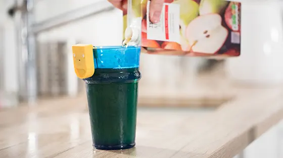 Person pouring cold drink using liquid level indicator