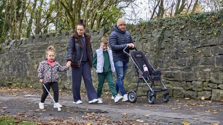Mabel and her family are going for a walk along a footpath. Mabel is using her white cane