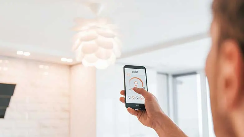 A man operating a smart lightbulb from his phone. 
