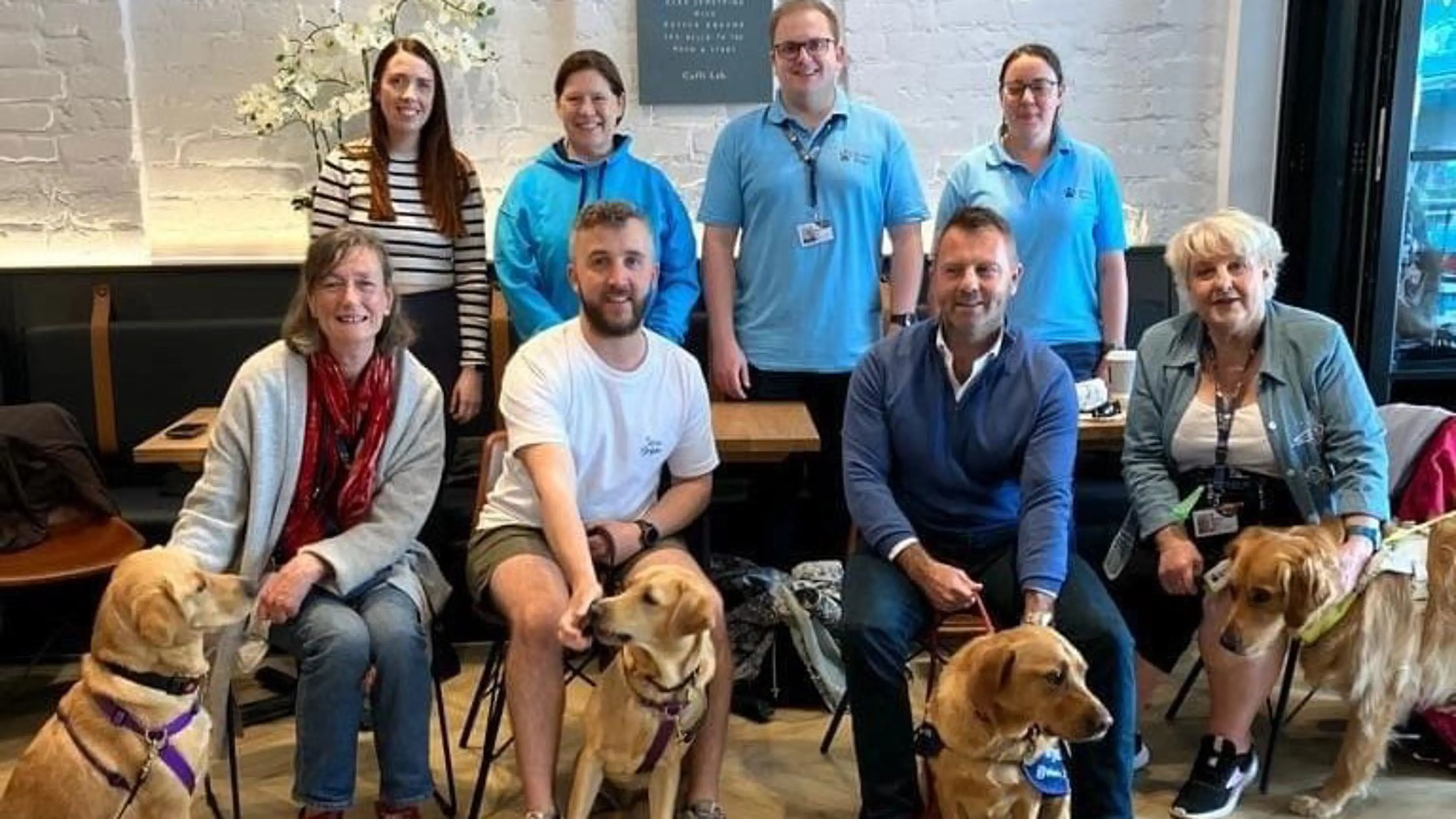 Charity of the Year Coffi Lab colleagues sitting in a café with dogs 